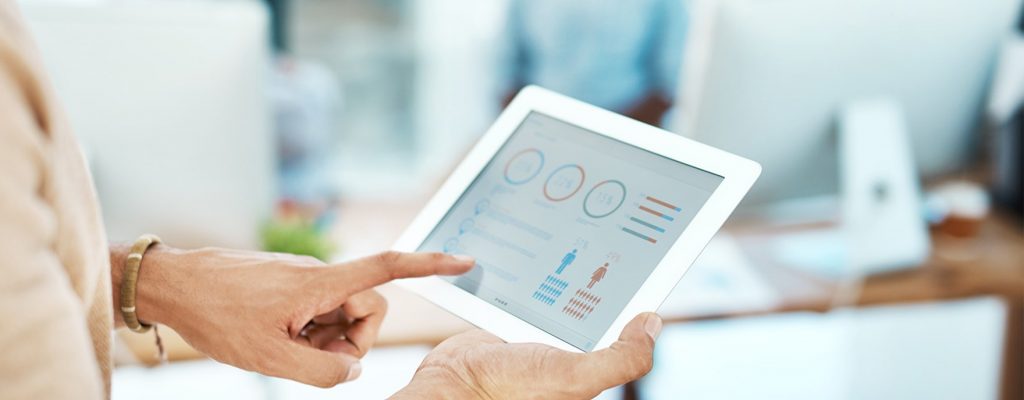 Close up photo of a person's hand pointing to statistics on a tablet screen.