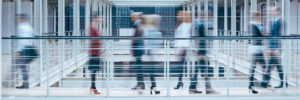Blurred photo of business people walking through walkway.